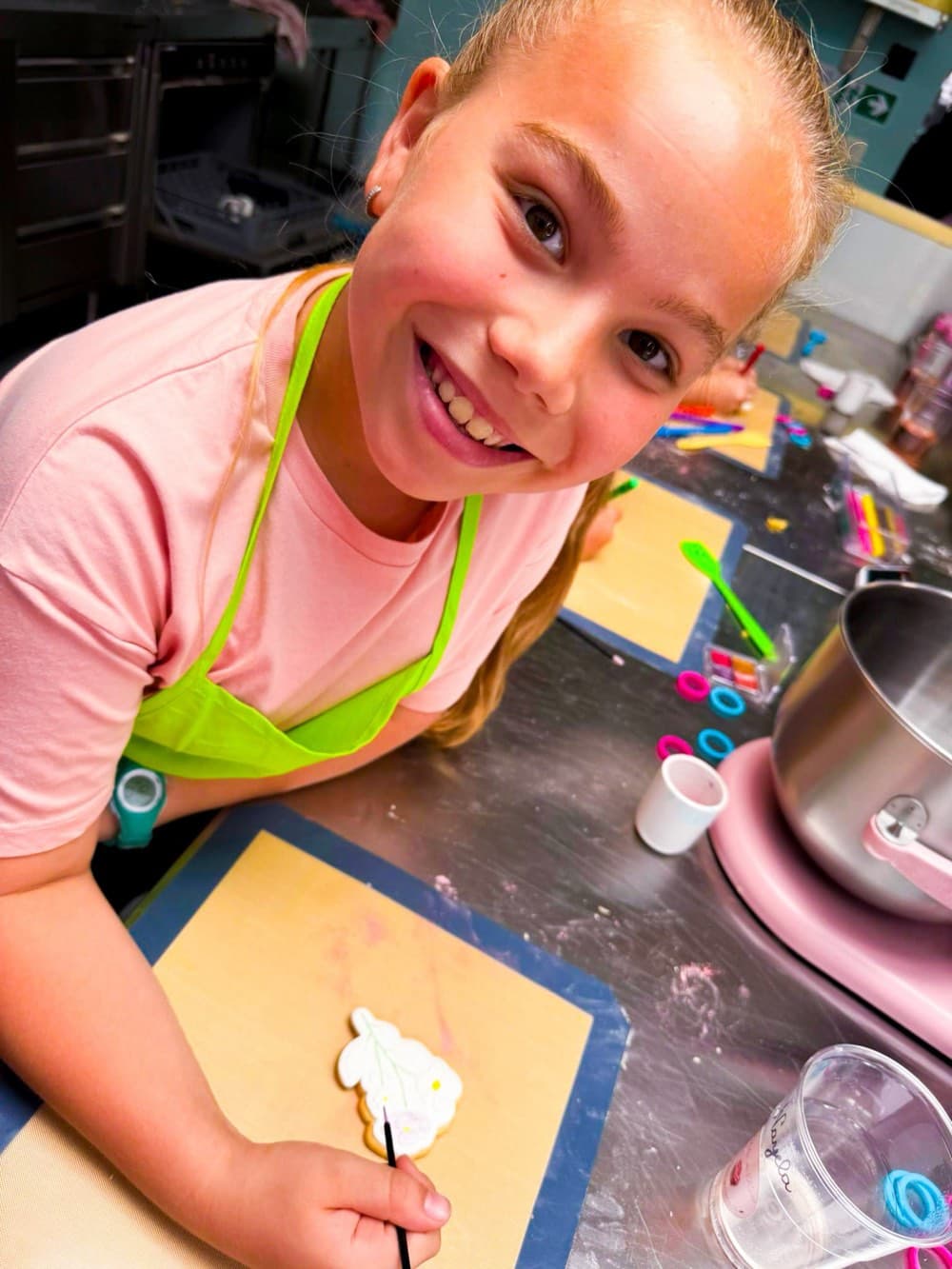 Petite fille souriante décorant un biscuit