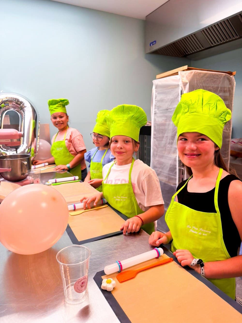Enfants en toques vertes préparant la pâte